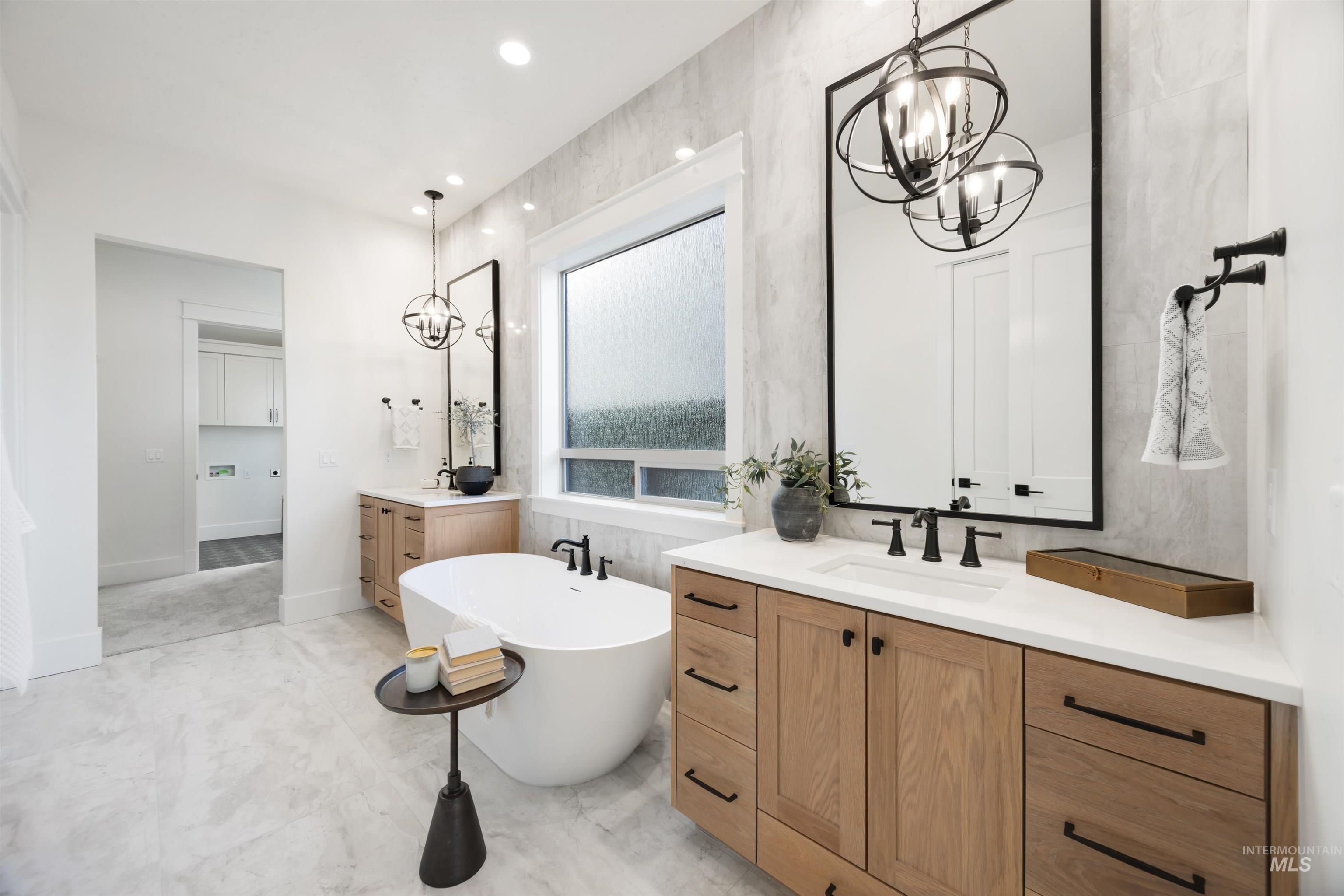 1034 East Escalation Street Meridian, ID 83642 - Photo 22 of 40 Bathroom featuring a chandelier, two vanities, a freestanding tub, and recessed lighting