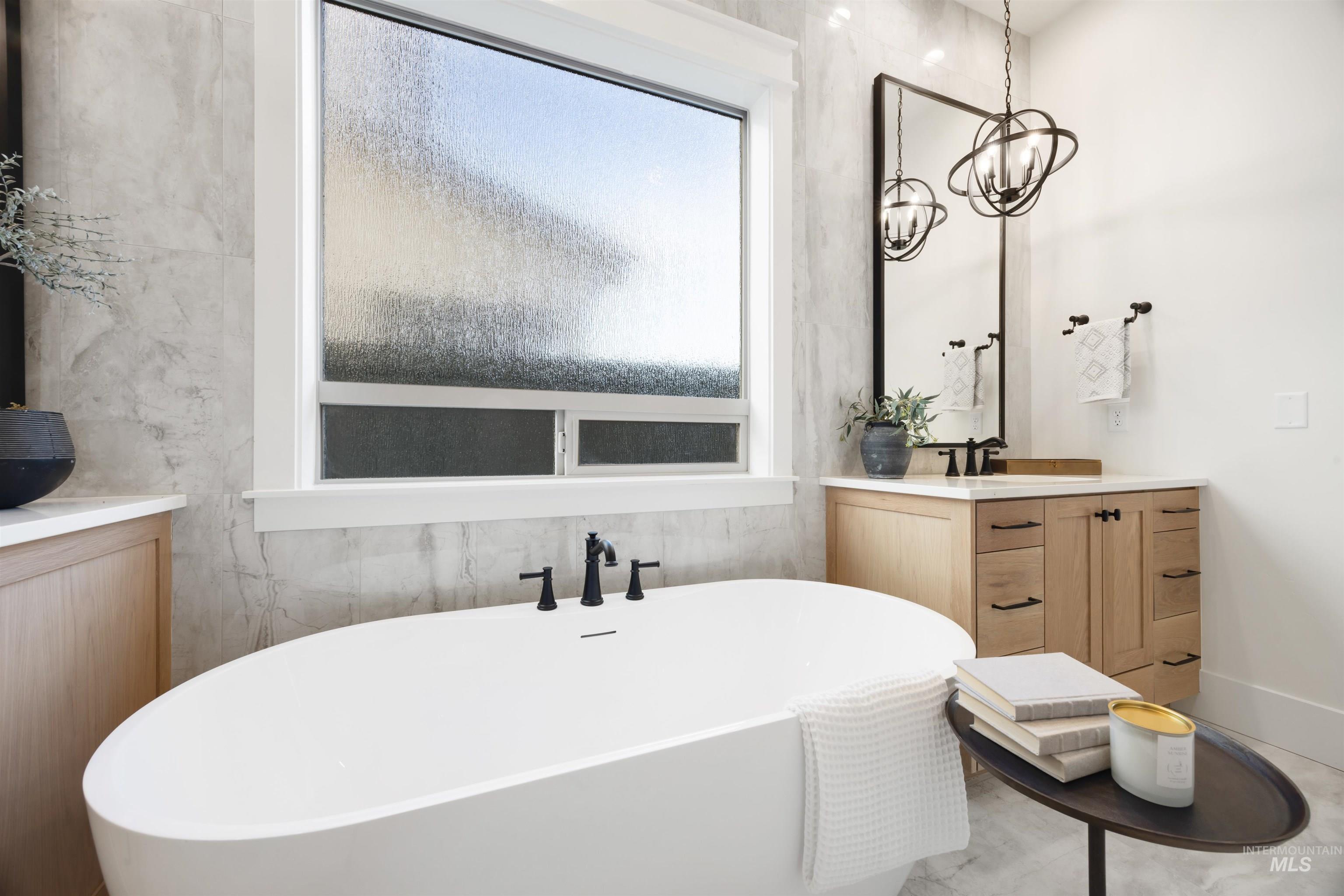 1034 East Escalation Street Meridian, ID 83642 - Photo 25 of 40 Bathroom with vanity, a soaking tub, and a chandelier
