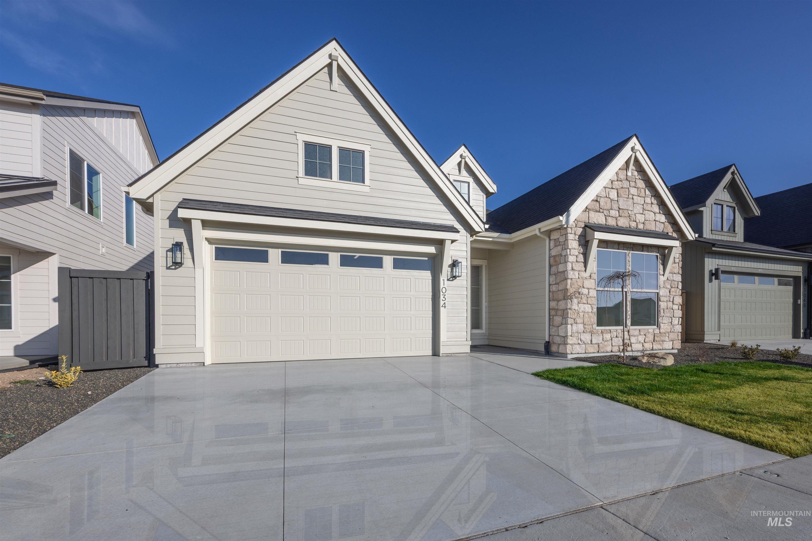 1034 East Escalation Street Meridian, ID 83642 - Photo 39 of 40 View of front of house featuring stone siding, driveway, and a front yard