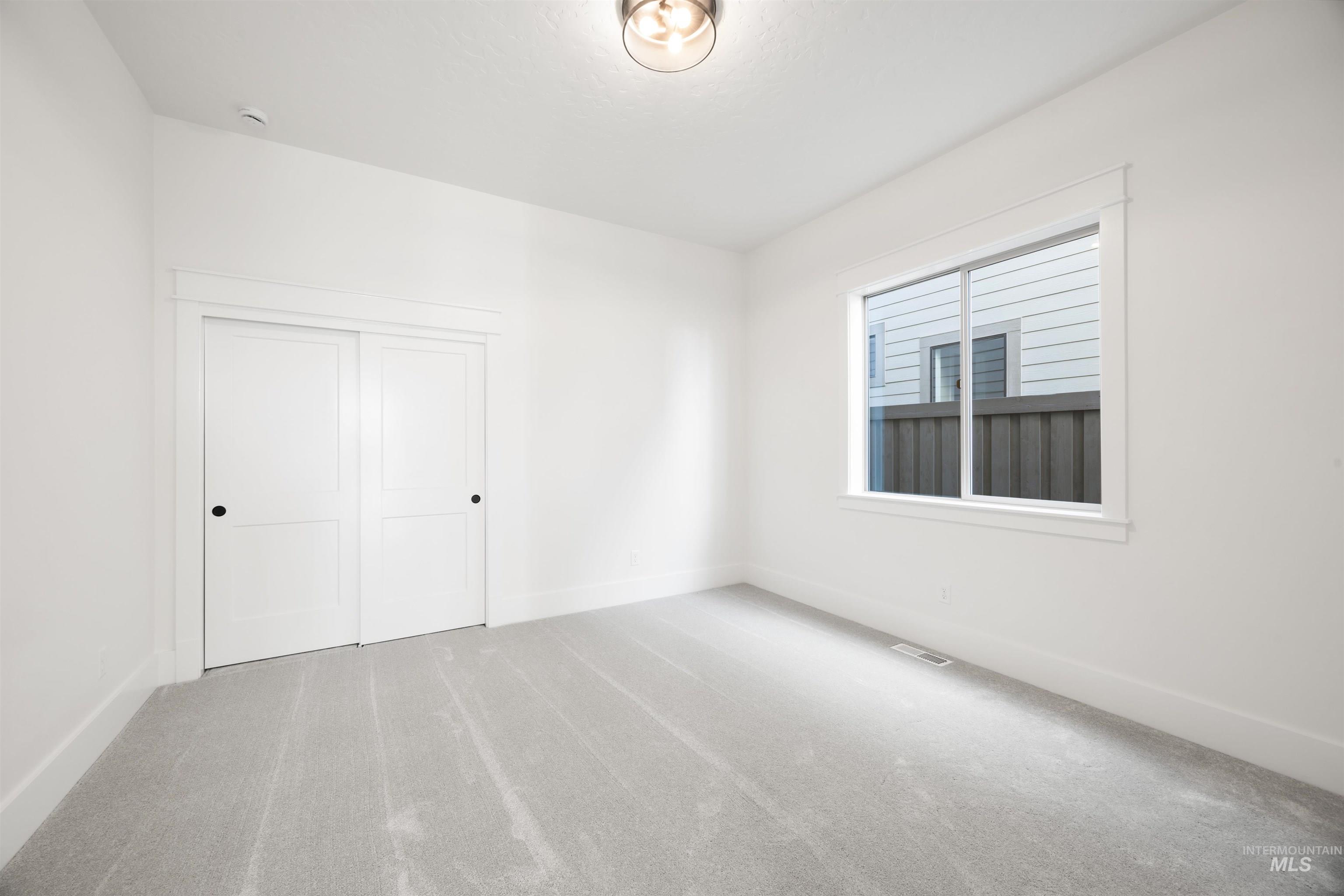 1034 East Escalation Street Meridian, ID 83642 - Photo 4 of 40 Unfurnished bedroom featuring light colored carpet and a closet
