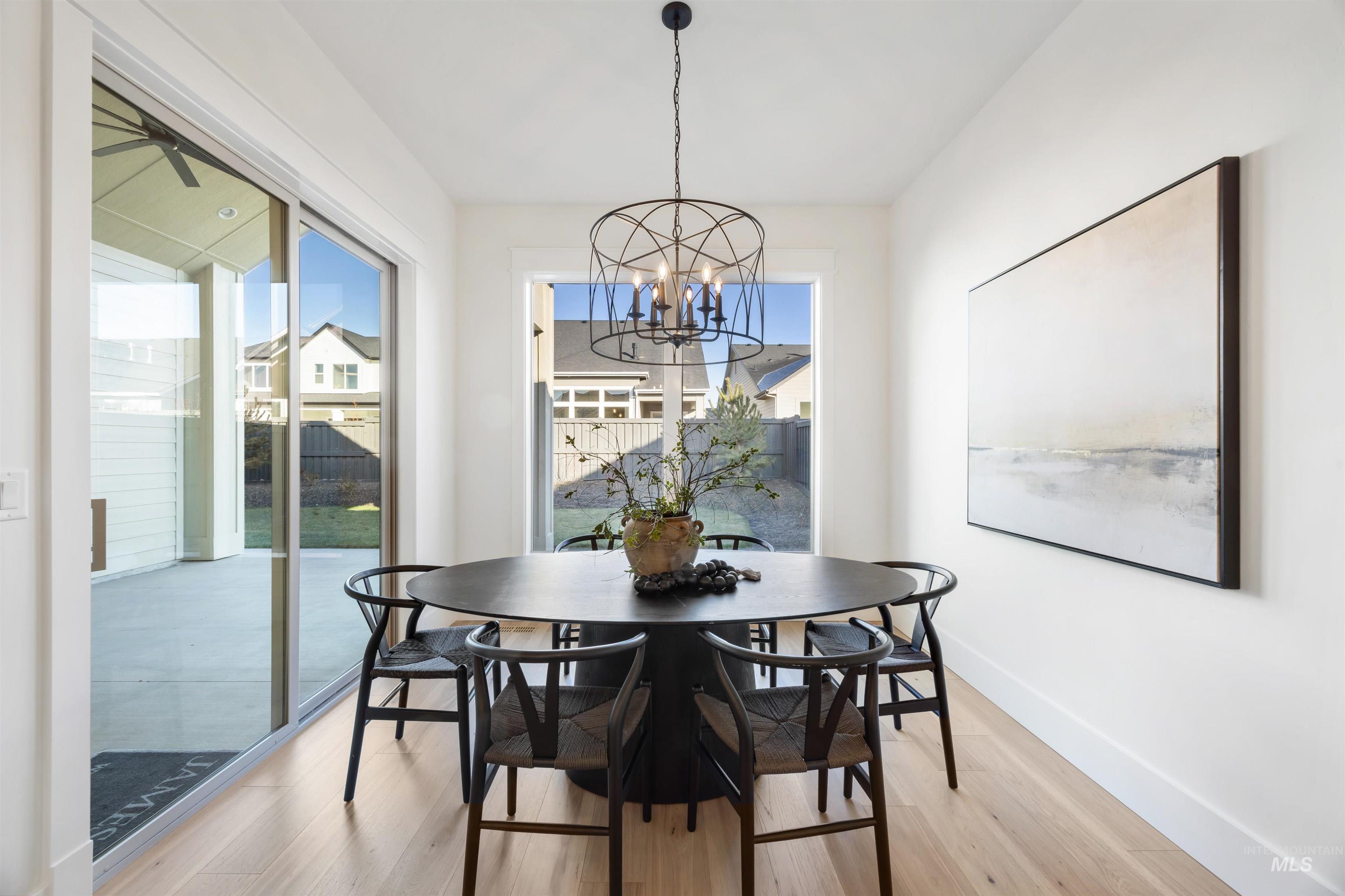 1034 East Escalation Street Meridian, ID 83642 - Photo 9 of 40 Dining room featuring wood finished floors, healthy amount of natural light, and a chandelier