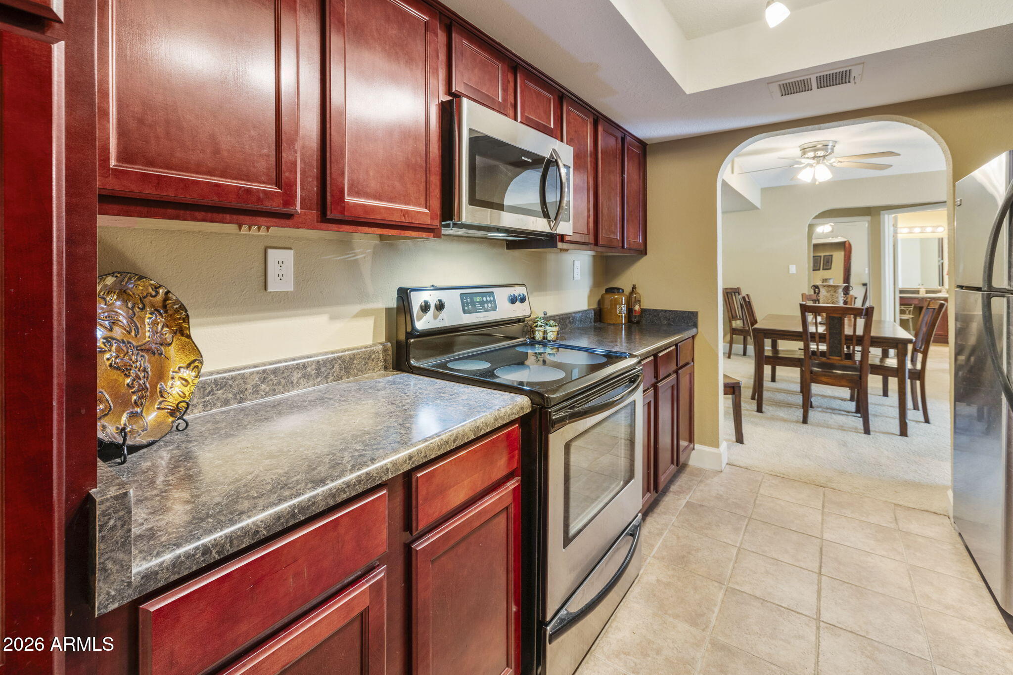3825 East Camelback Road, Unit 126 Phoenix, AZ 85018 - Photo 9 of 28 a kitchen with stainless steel appliances granite countertop a stove a sink and a microwave