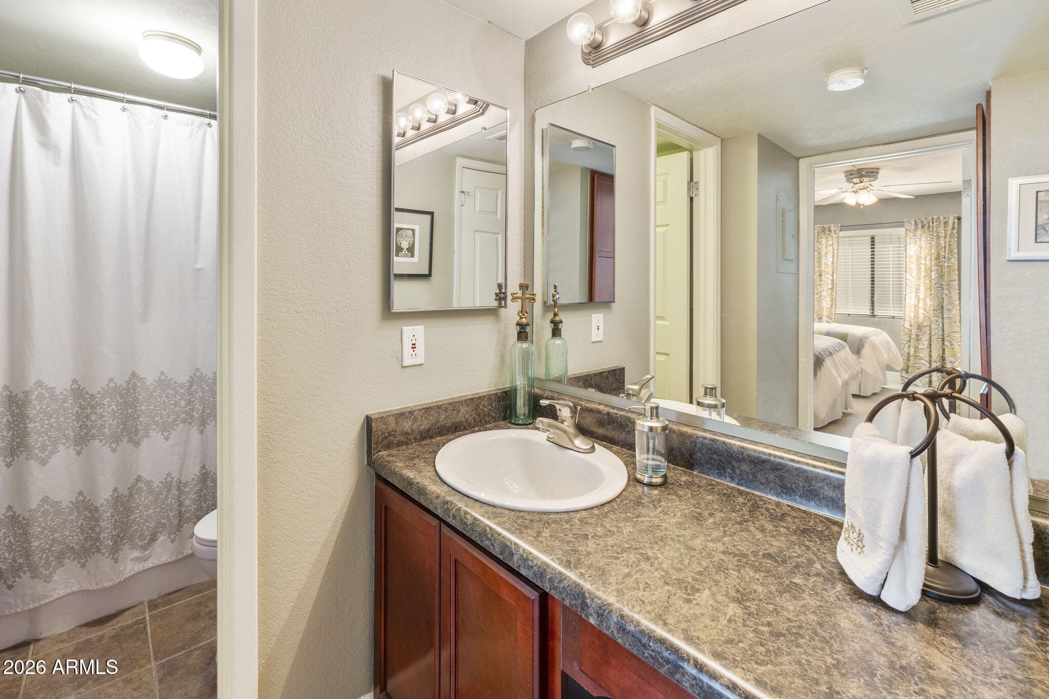 3825 East Camelback Road, Unit 126 Phoenix, AZ 85018 - Photo 17 of 28 a bathroom with a granite countertop sink and a mirror