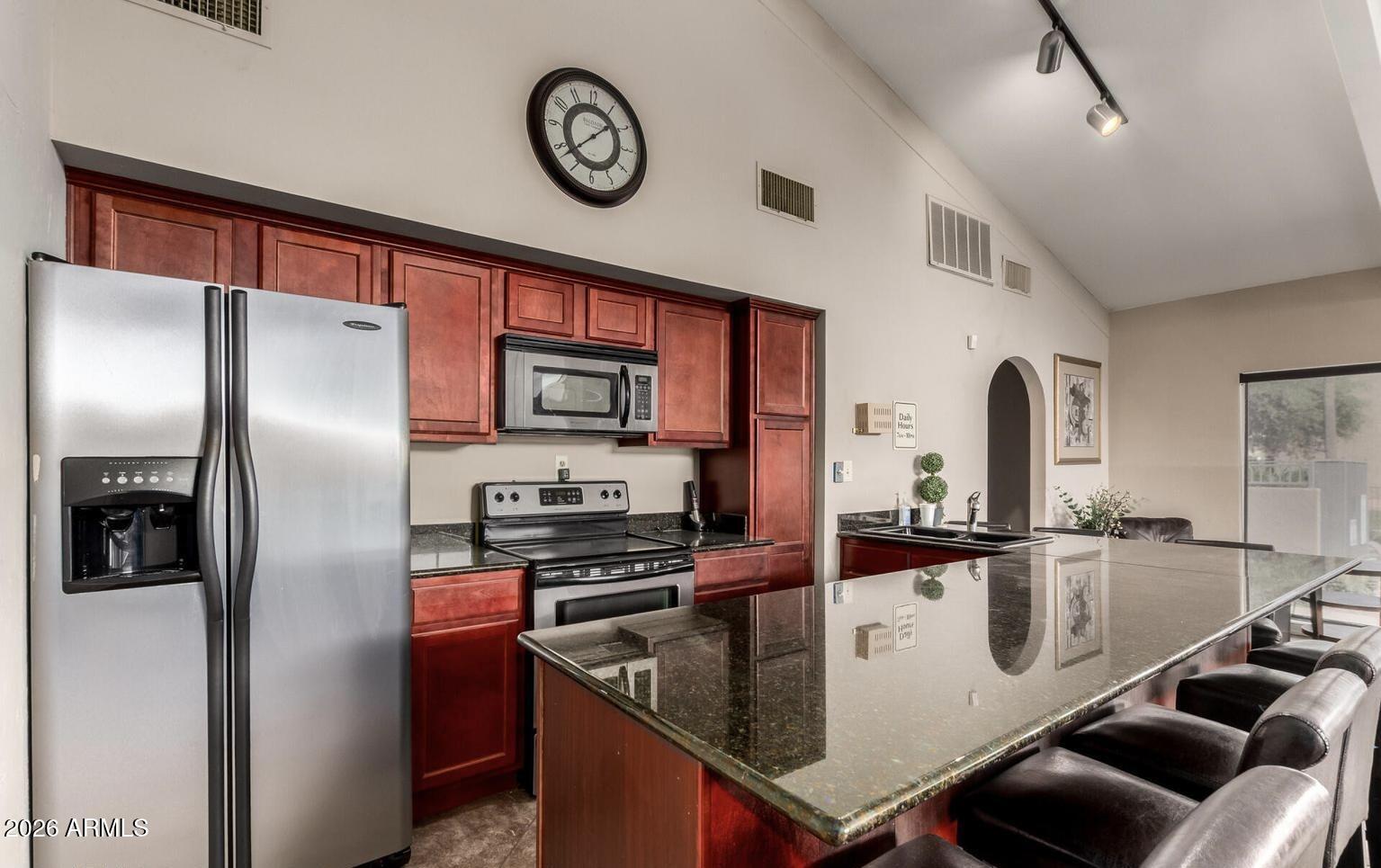 3825 East Camelback Road, Unit 126 Phoenix, AZ 85018 - Photo 25 of 28 a kitchen with stainless steel appliances granite countertop a sink a stove and a refrigerator