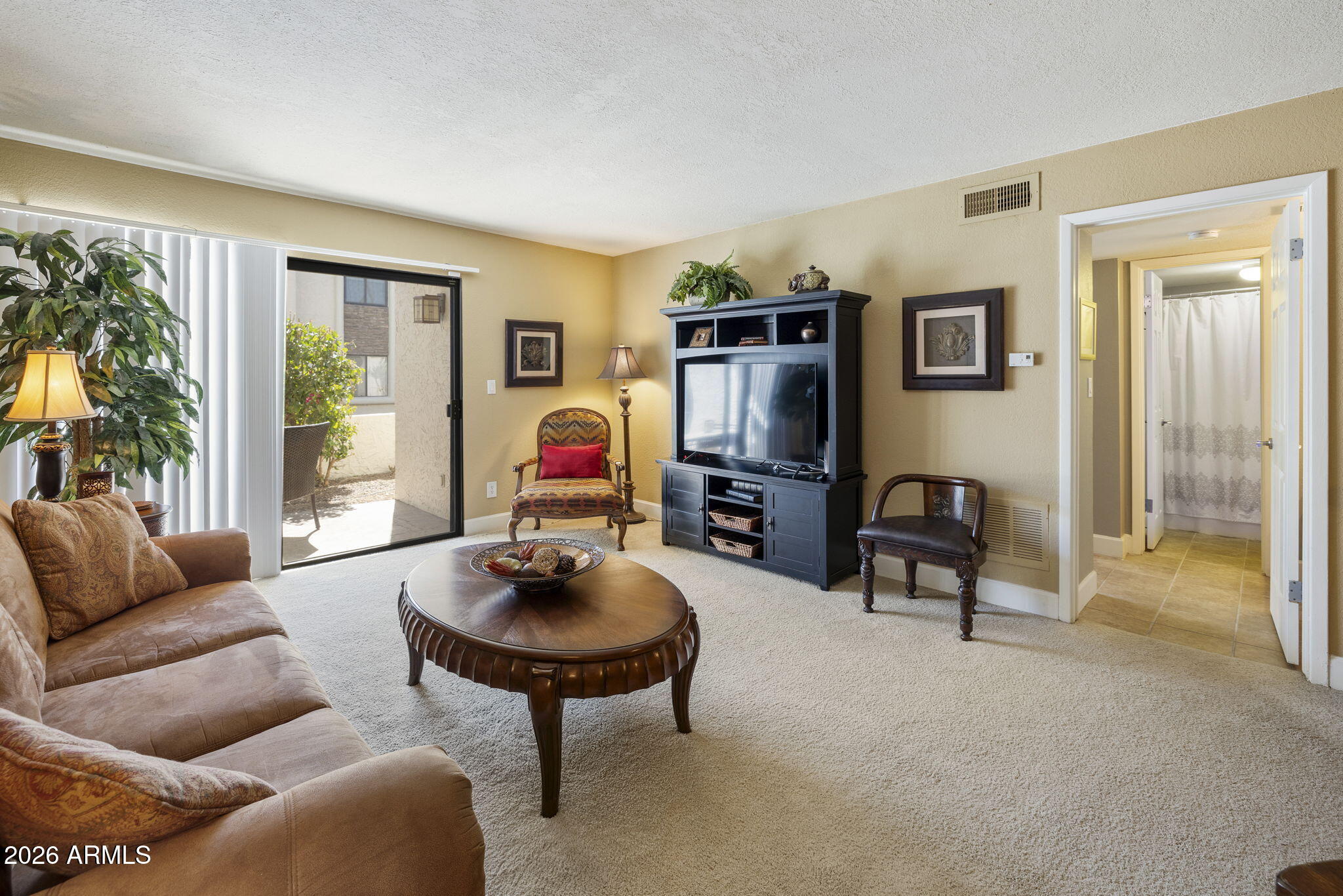 3825 East Camelback Road, Unit 126 Phoenix, AZ 85018 - Photo 3 of 28 a living room with furniture a flat screen tv and a large window