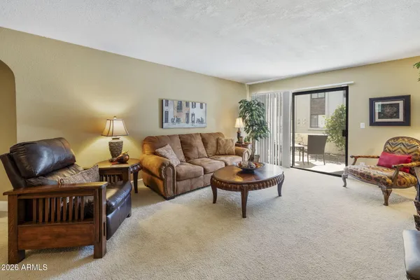 a living room with furniture a flat screen tv and a large window