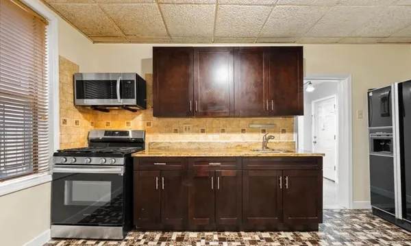 a kitchen with granite countertop a stove and a microwave