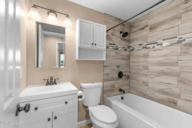 a bathroom with a bathtub shower sink vanity and toilet