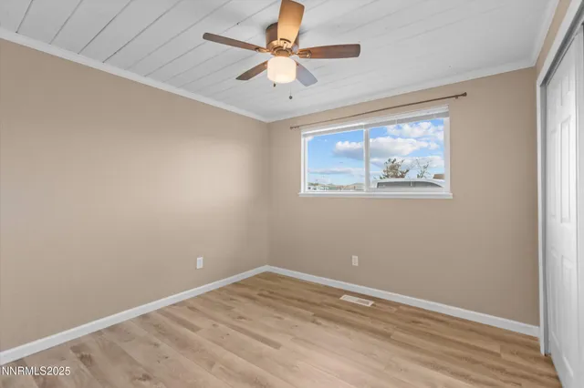 an empty room with a window and a ceiling fan