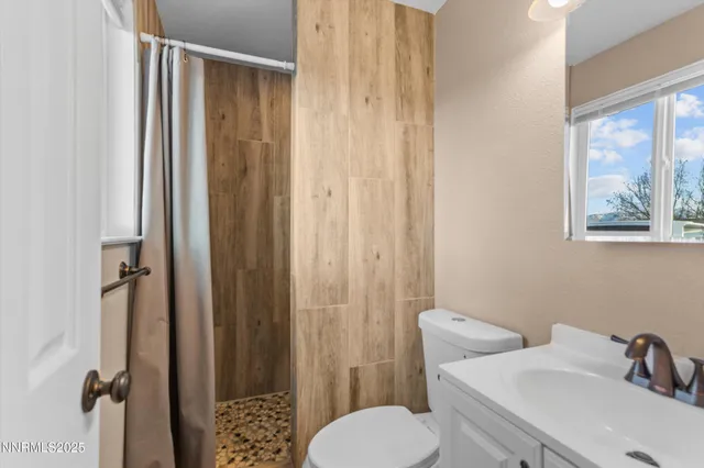 a bathroom with a toilet a sink and shower curtain