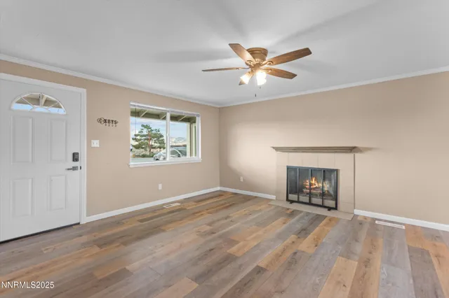 a view of an empty room with a window and a fireplace