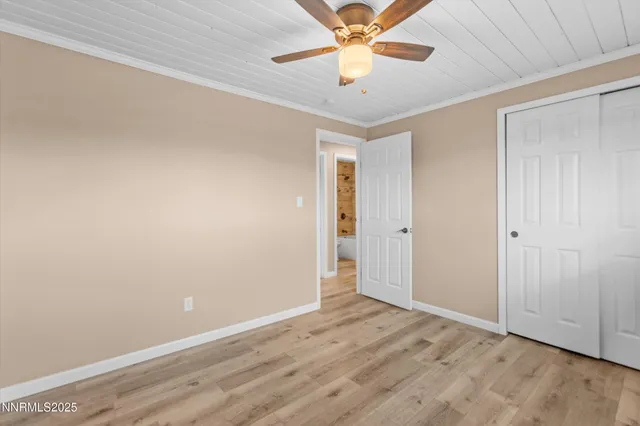 an empty room with a ceiling fan and wooden floor
