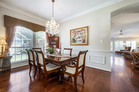 a dining room with furniture a chandelier and wooden floor