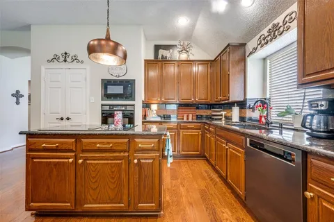 a kitchen with stainless steel appliances granite countertop a stove a sink and a refrigerator