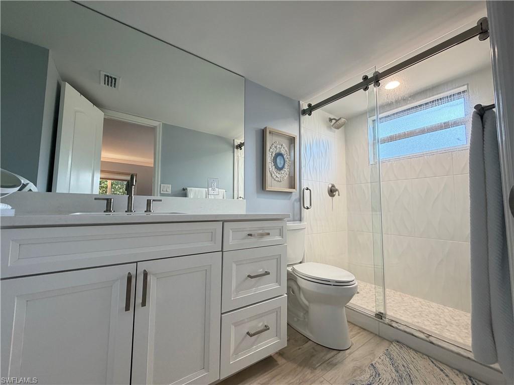 960 7th Street South, Unit 103 Naples, FL 34102 - Photo 11 of 16 a bathroom with a toilet sink and mirror