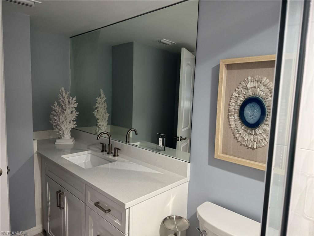 960 7th Street South, Unit 103 Naples, FL 34102 - Photo 12 of 16 a bathroom with a sink a toilet and a mirror