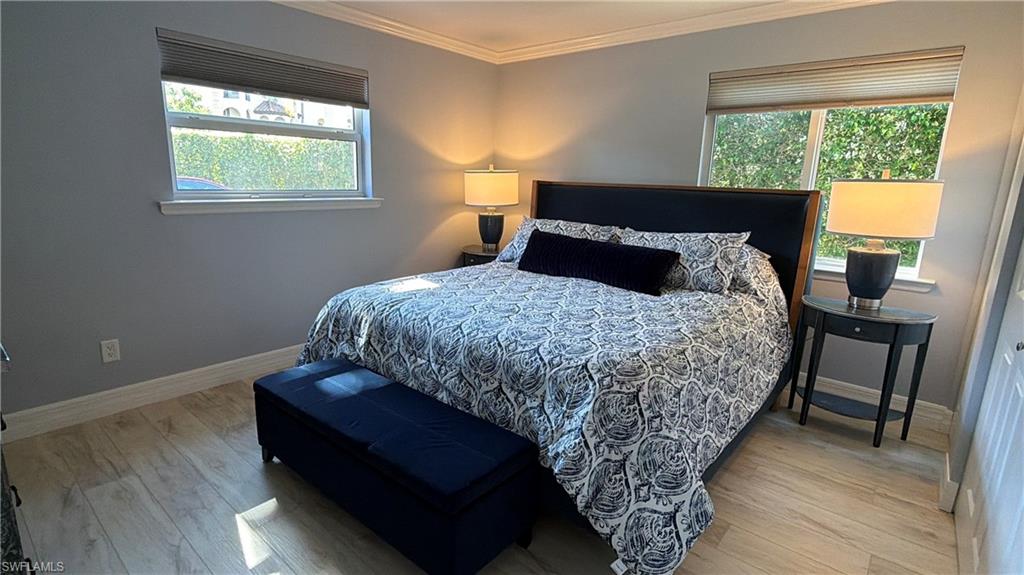960 7th Street South, Unit 103 Naples, FL 34102 - Photo 14 of 16 a bedroom with a bed and wooden floor