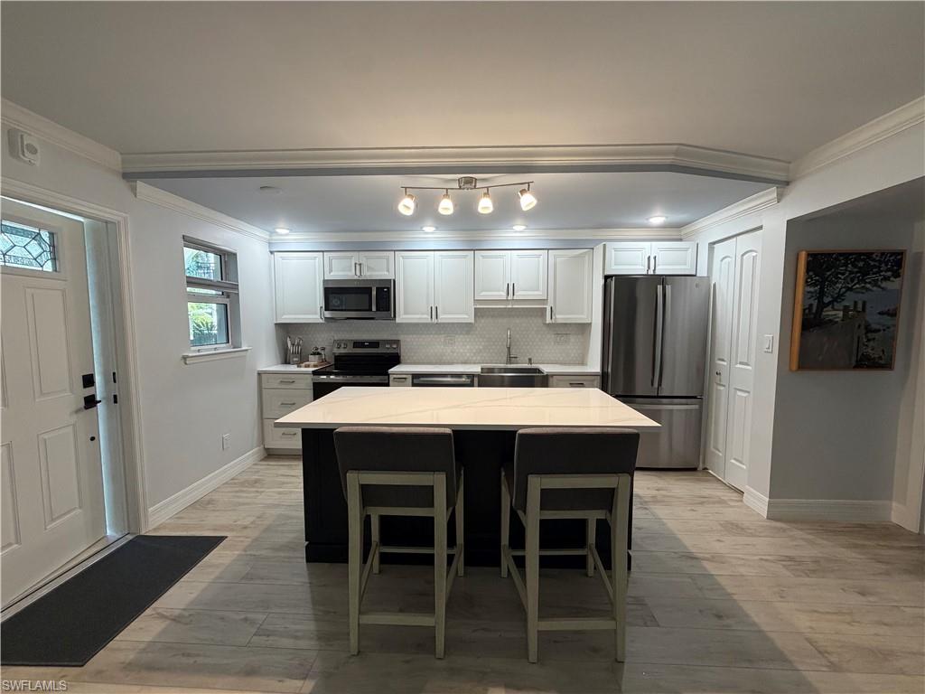 960 7th Street South, Unit 103 Naples, FL 34102 - Photo 6 of 16 a large kitchen with a table and chairs