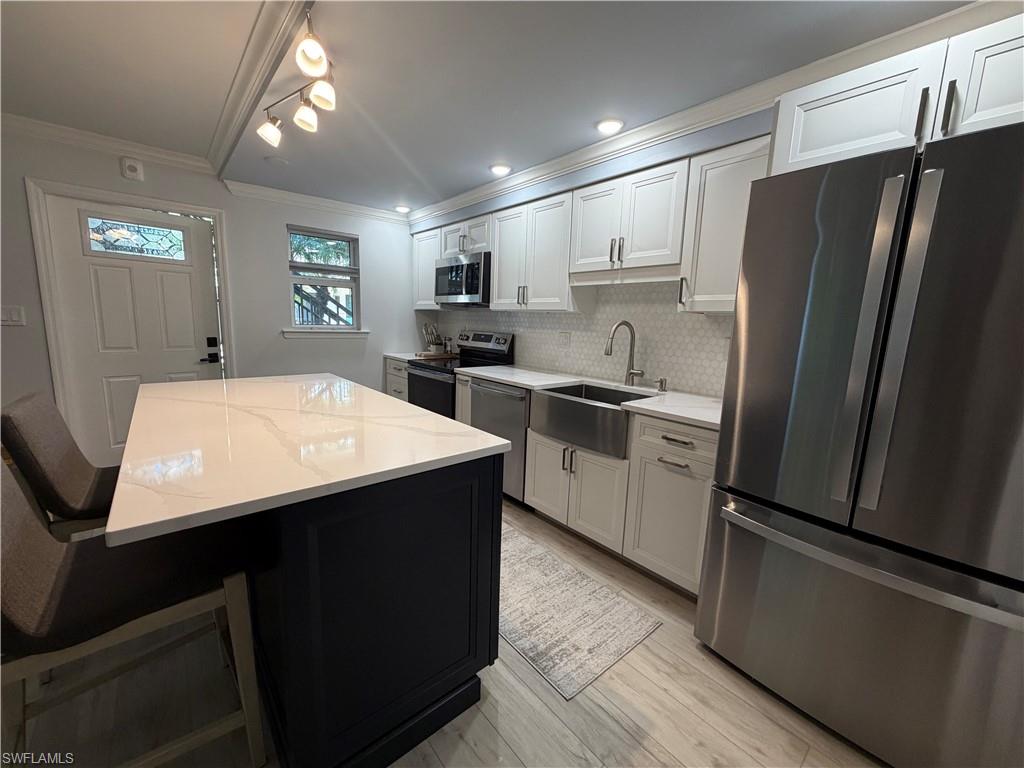 960 7th Street South, Unit 103 Naples, FL 34102 - Photo 10 of 16 a kitchen with stainless steel appliances a refrigerator and a stove