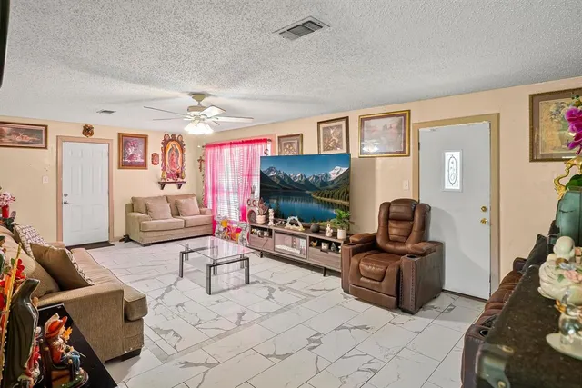a living room with furniture a flat screen tv and gym equipment