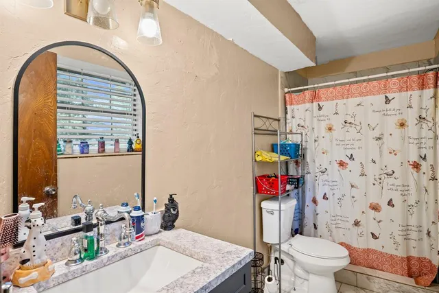 a bathroom with a sink toilet and shower