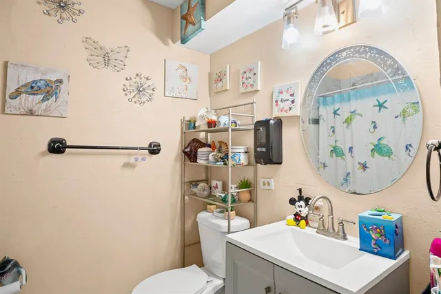a bathroom with a sink mirror vanity and toilet
