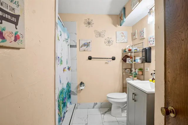 a bathroom with a toilet and a shower curtain