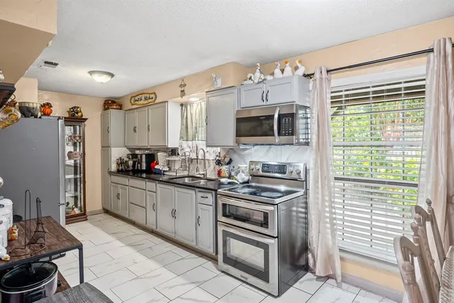 a kitchen with stainless steel appliances a stove sink microwave and cabinets