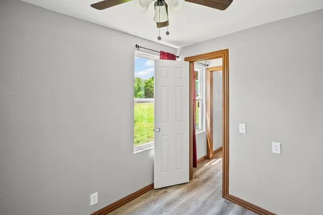 an empty room with a window and a fan