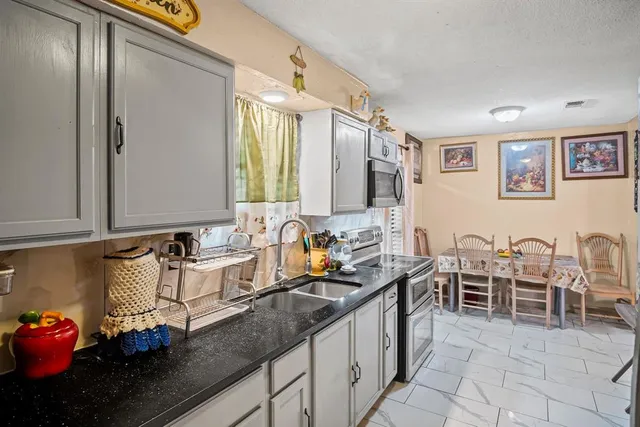 a kitchen with stainless steel appliances granite countertop sink cabinets and counter space