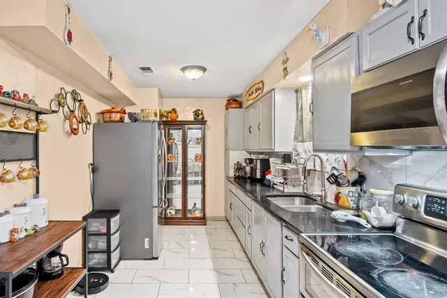 a kitchen with stainless steel appliances granite countertop a sink stove and refrigerator