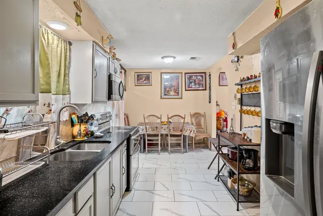 a kitchen with stainless steel appliances granite countertop a refrigerator and a sink