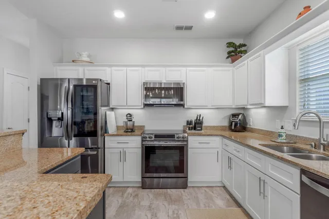 a kitchen with stainless steel appliances granite countertop a stove sink and refrigerator