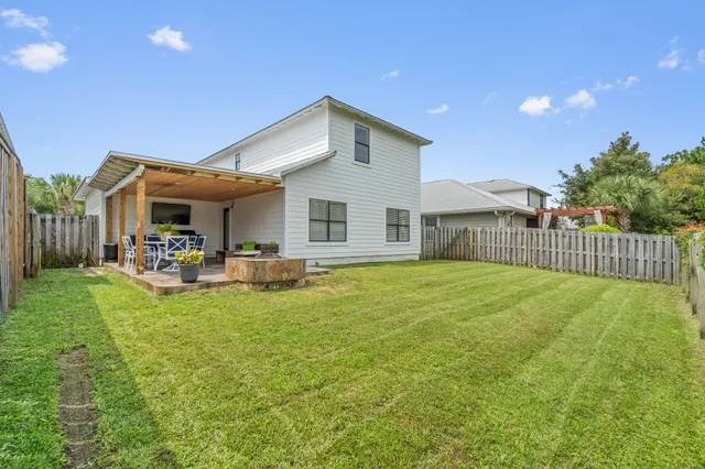 a view of a house with backyard and sitting area