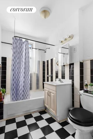 a kitchen with a checkered floor and white cabinets