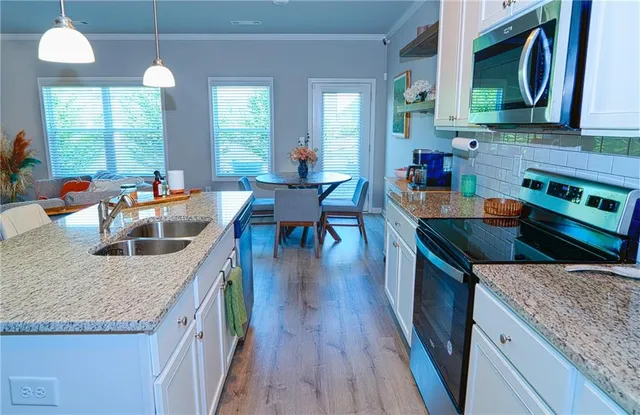 a kitchen with granite countertop a sink a counter top space and living room area