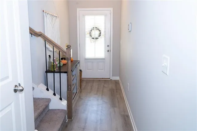 a view of a hallway with wooden floor and staircase