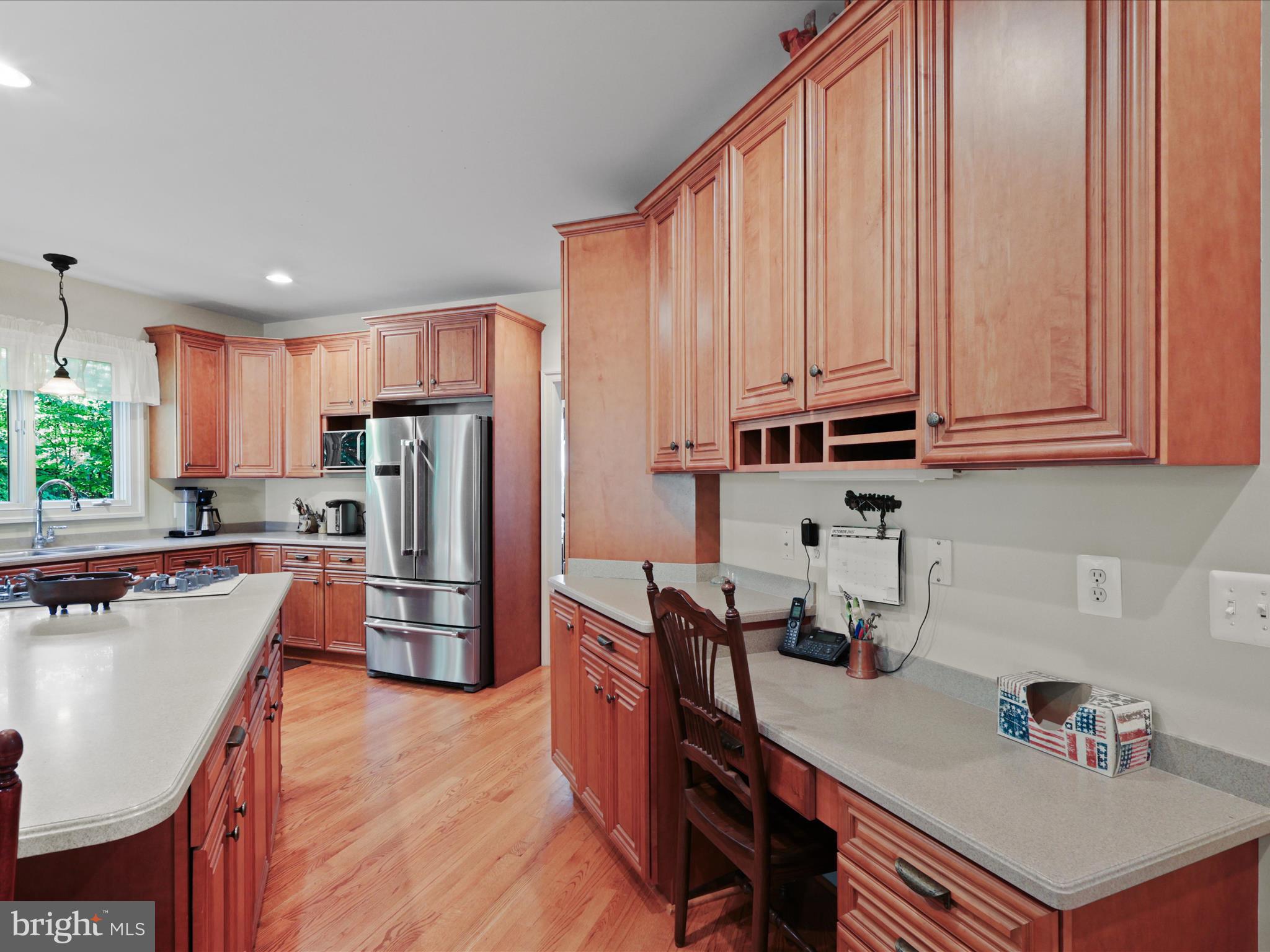 12848 Redbird Ridge Clifton, VA 20124 - Photo 13 of 76 a kitchen with stainless steel appliances granite countertop a refrigerator a sink dishwasher a stove and white countertops with wooden floor