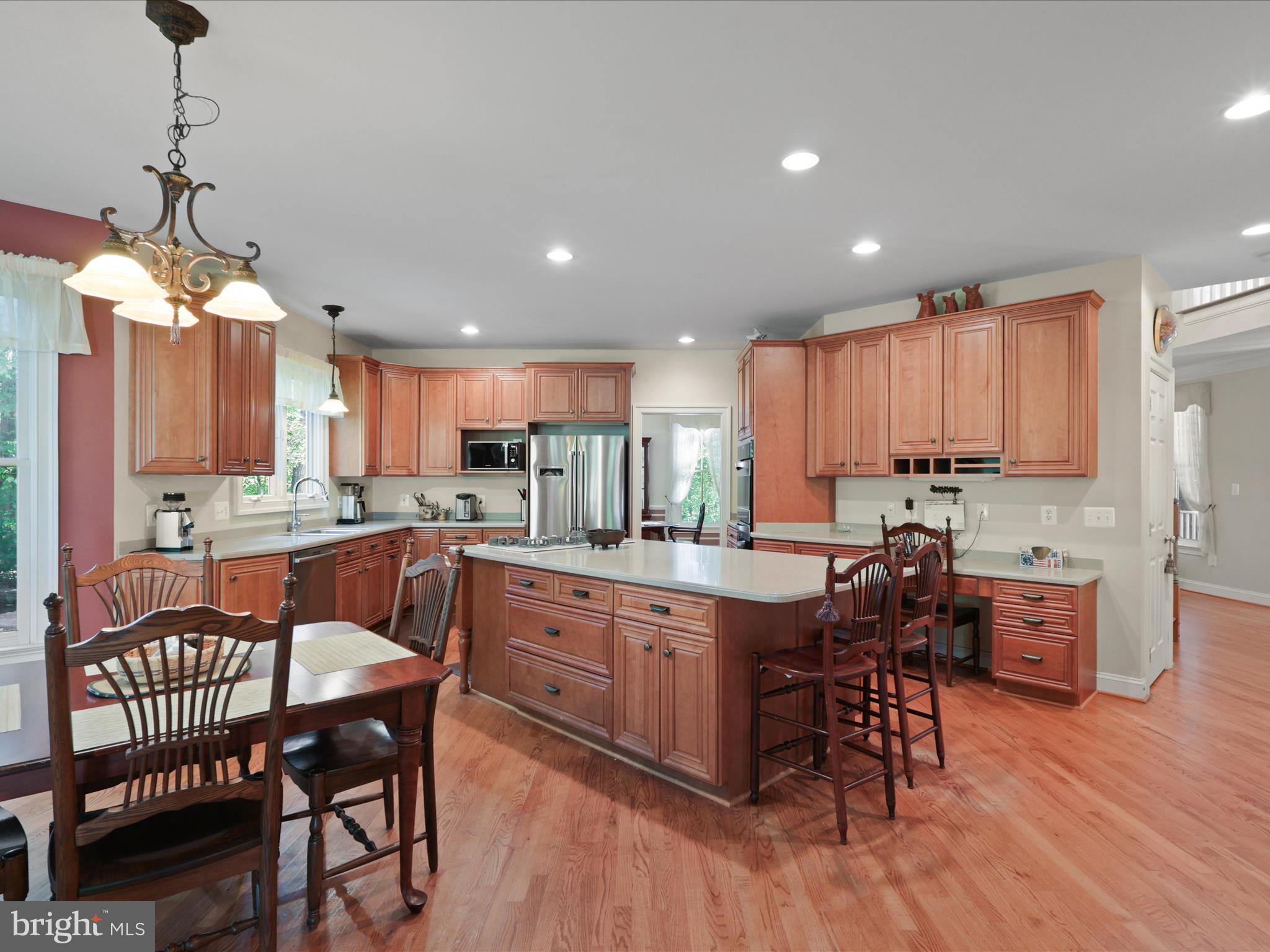 12848 Redbird Ridge Clifton, VA 20124 - Photo 16 of 76 a kitchen with stainless steel appliances granite countertop a table chairs sink refrigerator and cabinets
