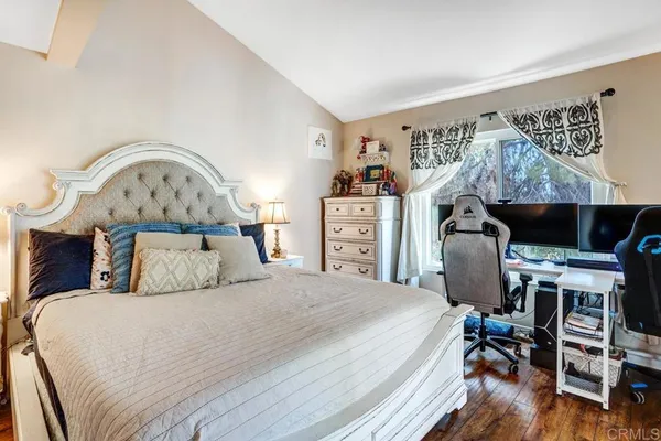 a bedroom with a bed a dresser and a television