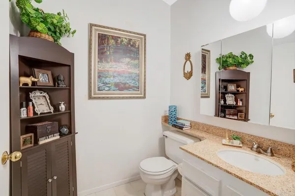 a bathroom with a granite countertop sink a toilet and a mirror