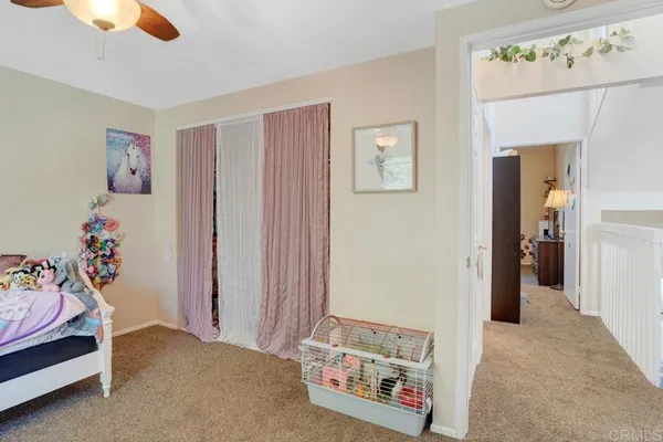 a view of a bedroom with baby crib and toys