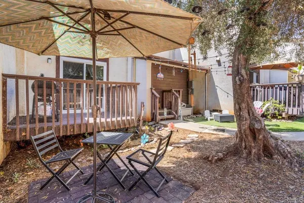 a view of a chair and table in backyard of the house