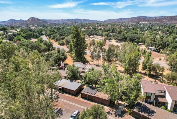 an aerial view of residential houses with outdoor space and mountain view