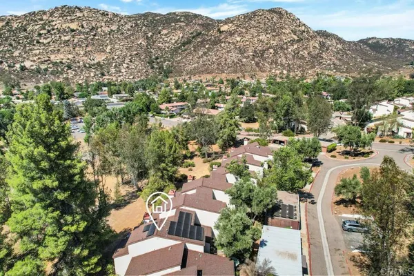 an aerial view of residential house with outdoor space and trees all around