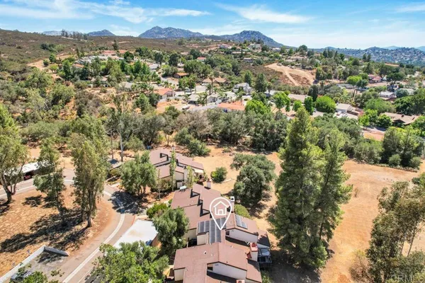 an aerial view of residential houses with outdoor space and trees