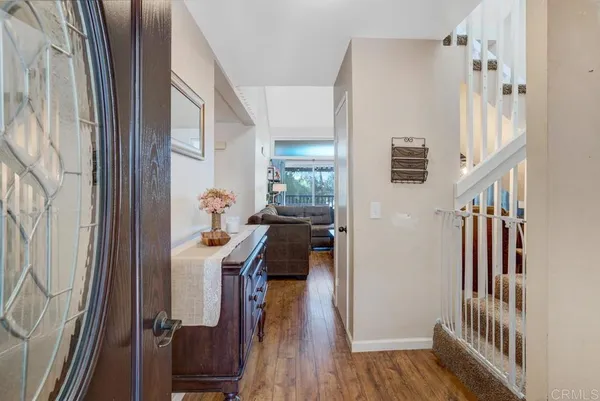 a view of a hallway with wooden floor and stairs