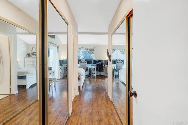 a view of a hallway and wooden floor a livingroom with furniture