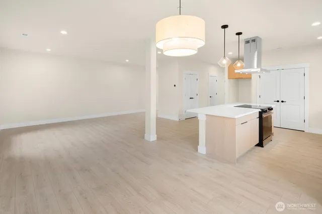 a view of kitchen with stainless steel appliances granite countertop a stove a sink dishwasher and a refrigerator with wooden floor