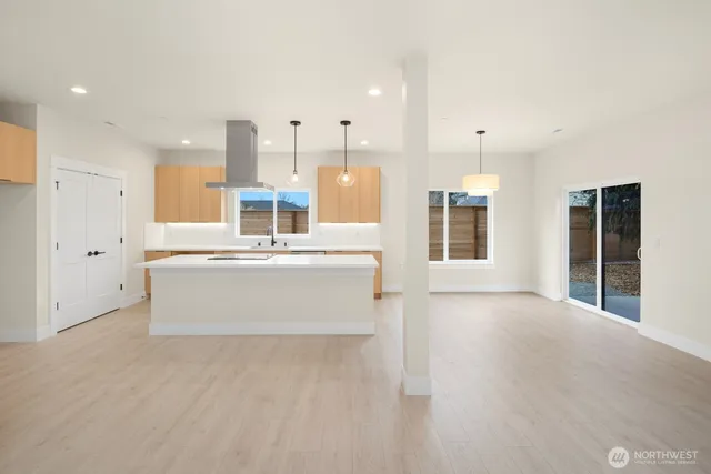 a view of kitchen with stainless steel appliances granite countertop wooden floor